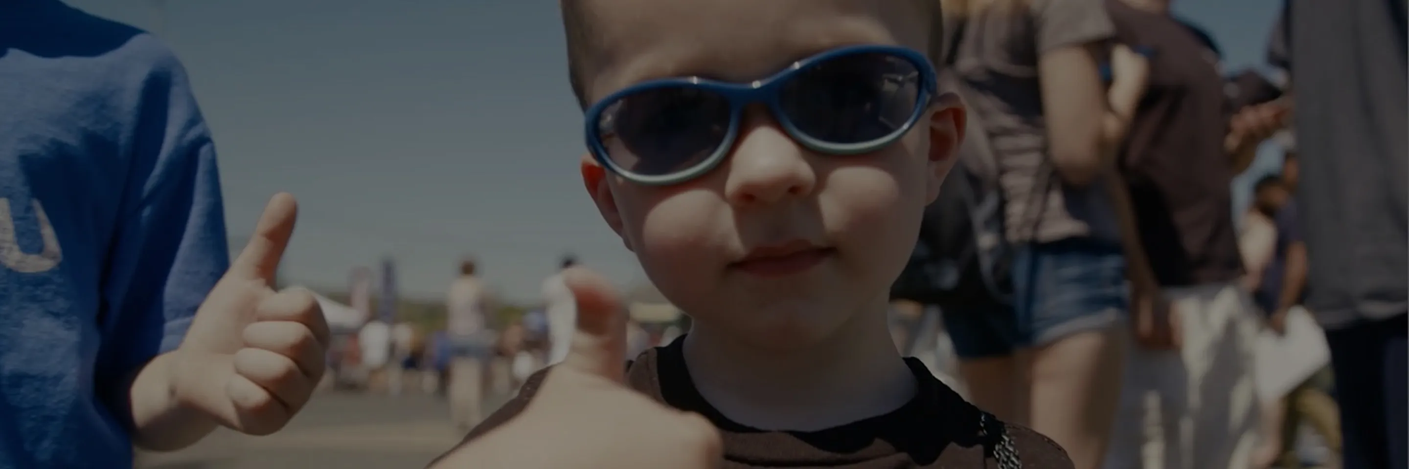 サングラスをかけてグッドサインをする子どもの写真