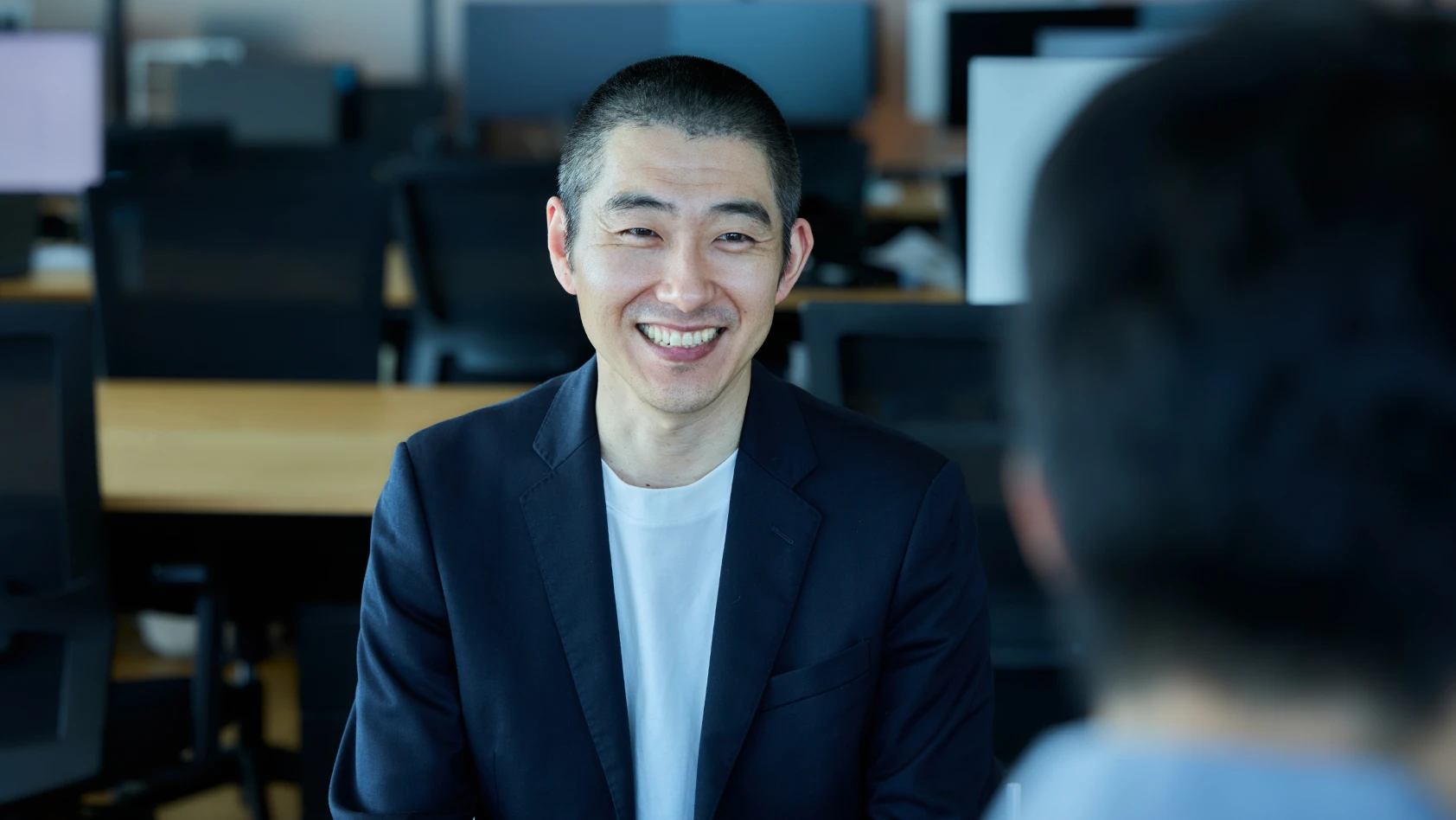金井が笑顔で話している様子