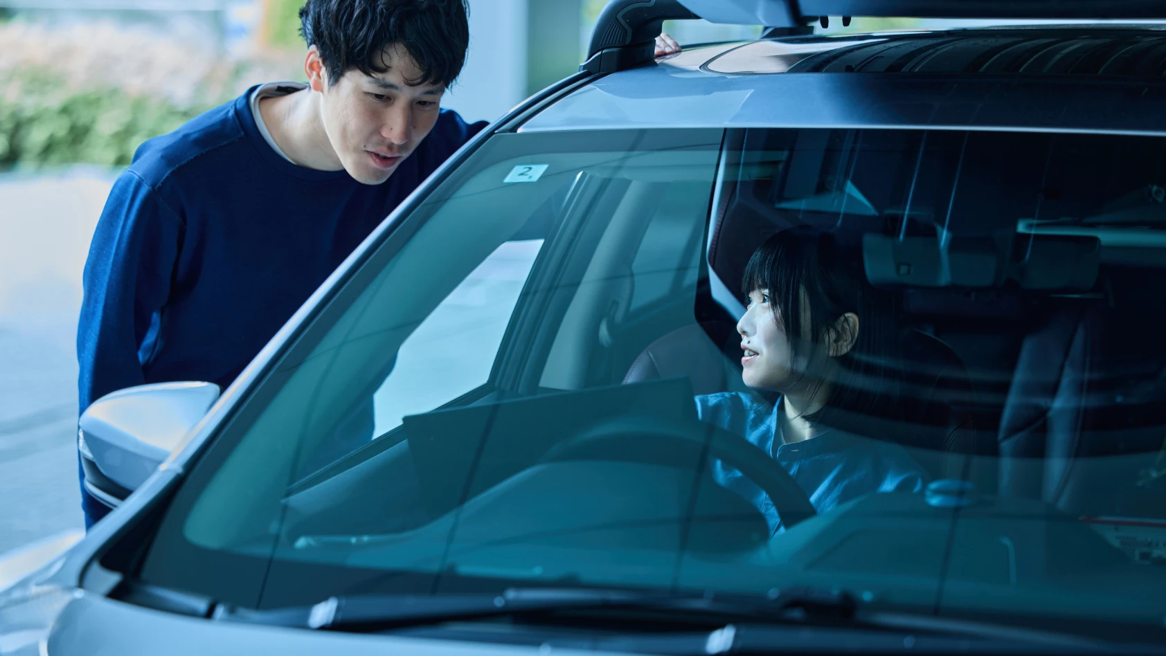 税所が車で他のスタッフと話をしている様子